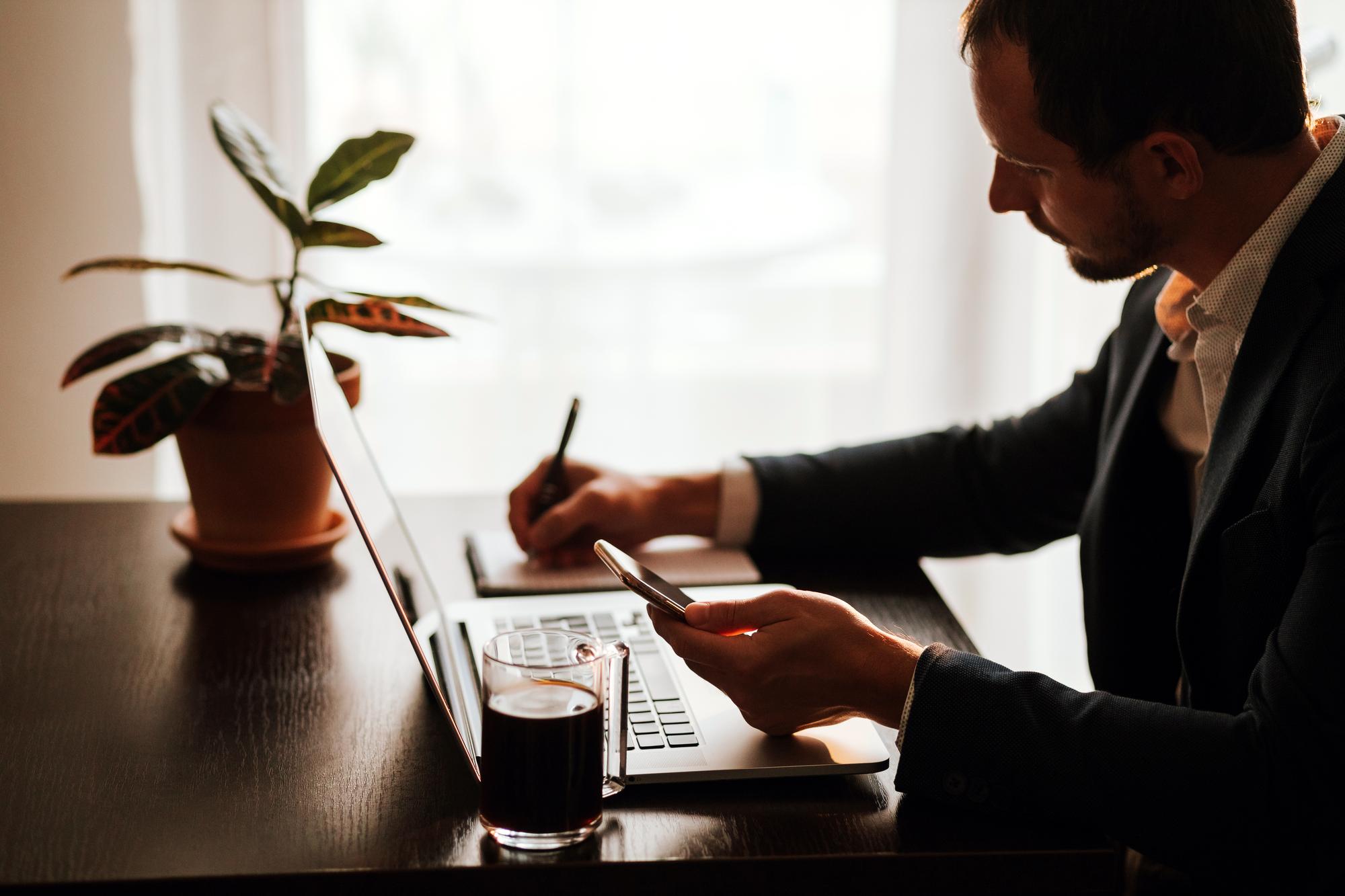 Person reviewing documents at a premium desk with notebook and coffee